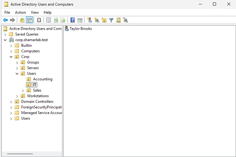 The IT OU selected in Active Directory Users and Computers with the Taylor Brooks user object visible
